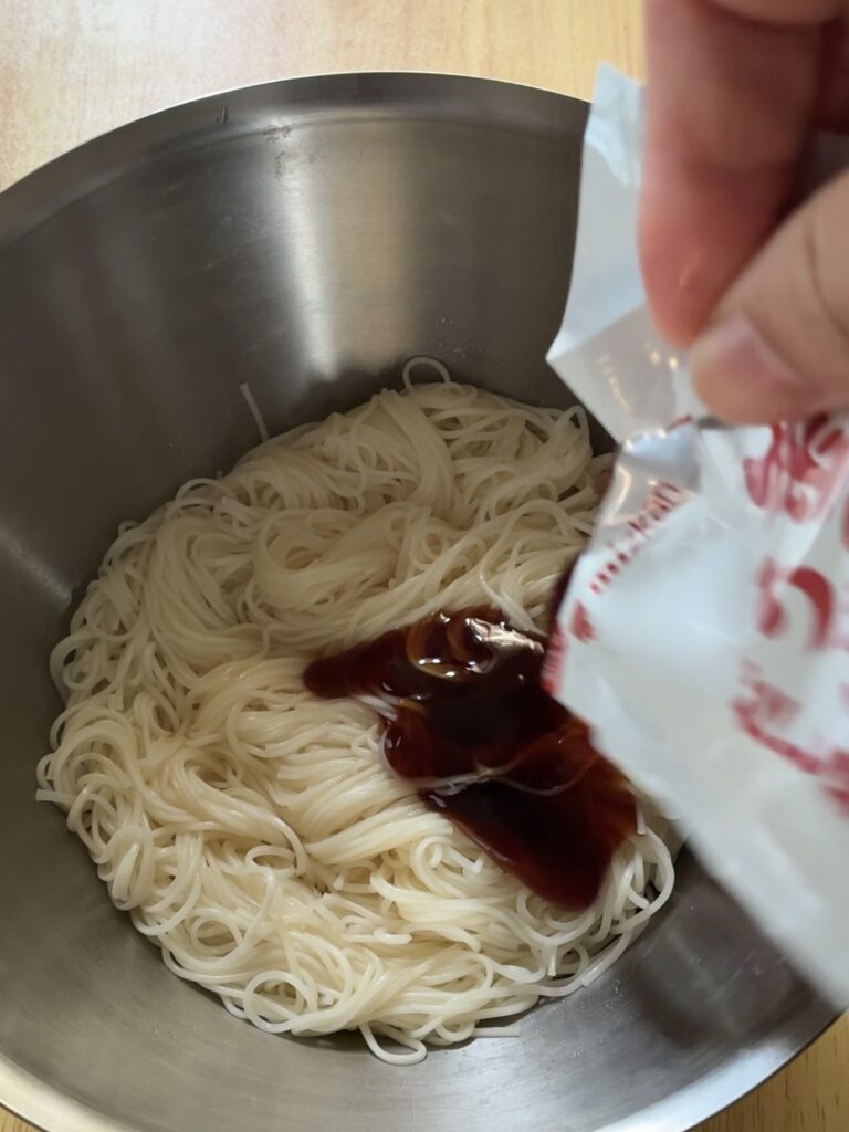 そうめんをうどんタレを入れている画像