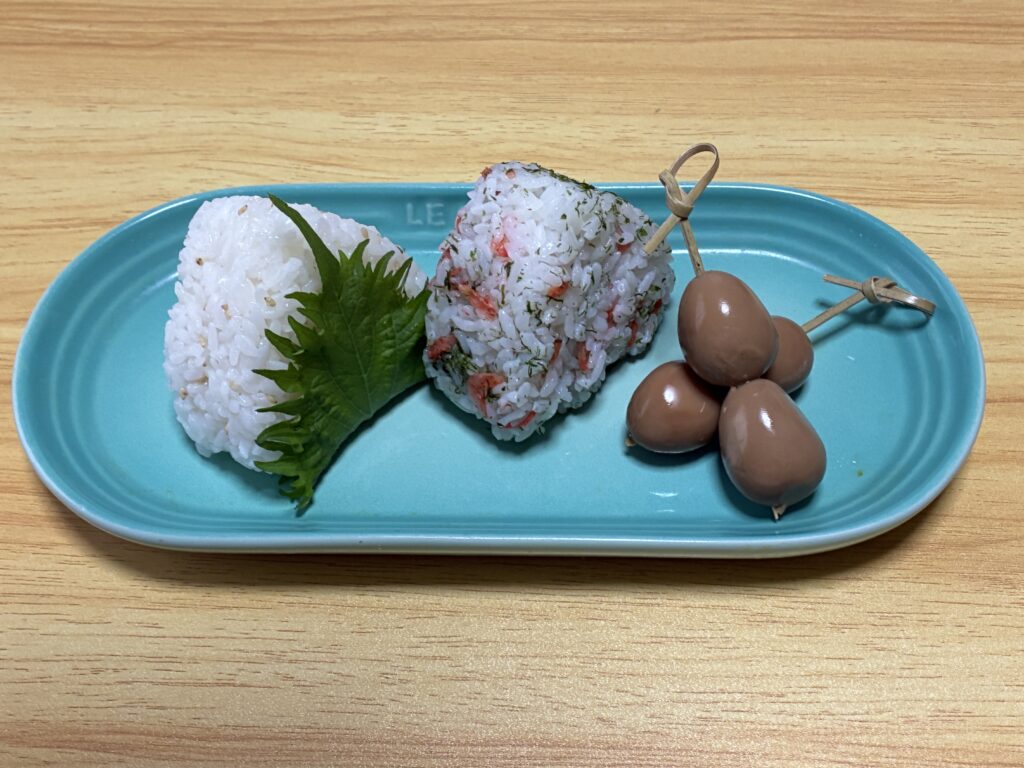 ル・クルーゼロングオブプレートにおにぎりとうずら串を乗せた画像